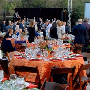 Fundraising dinner with tables, screen, and band
