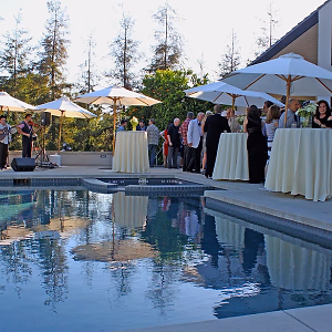 Cocktail hour guests enjoying bites and music by the pool