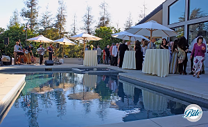 Cocktail hour guests enjoying bites and music by the pool