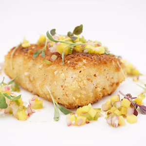 Mahi Mahi plated w/ mango salsa. Closeup corner view