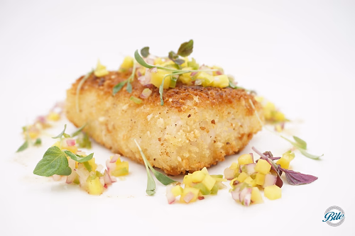 Mahi Mahi plated w/ mango salsa. Closeup corner view