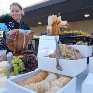 Charcuterie station with chef slicing prosciutto