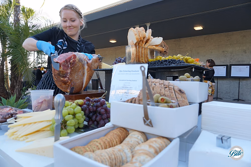 Charcuterie station with chef slicing prosciutto