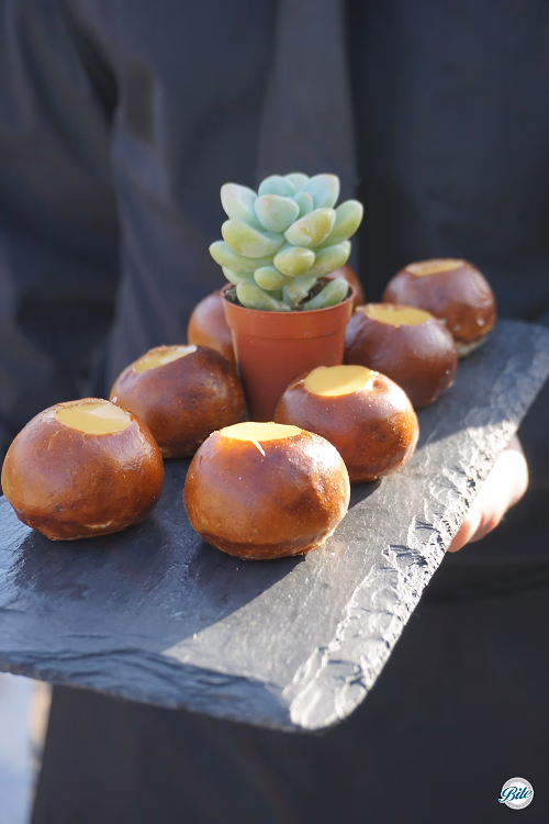 Pretzel canapes w/ cheese fondue and server in black