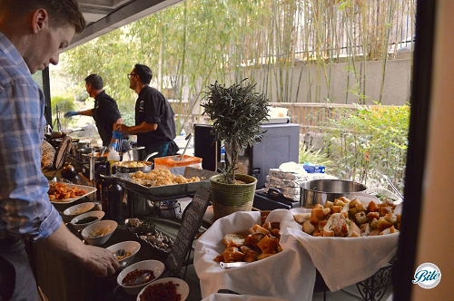 Guest Selecting Toppings from Pasta Station