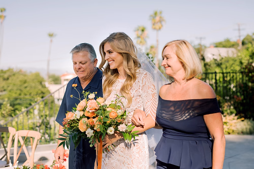 Our beautiful bride is escorted to her handsome groom in the family's backyard