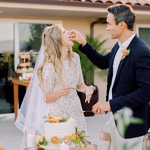 The groom feeds his beautiful bride and bite of their wedding cake