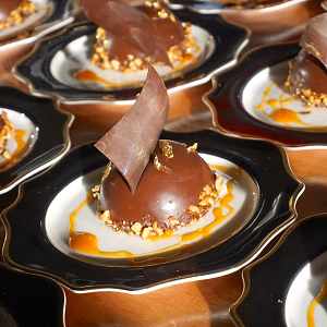 Chocolate passion fruit dome with edible gold décor and hazelnuts