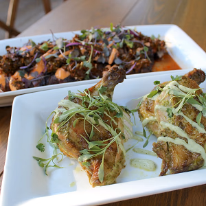 free-range cilantro-ginger airline chicken with a roasted jalapeno-lime crema and seared thinly-sliced cassis and red wine marinated flank steak with housemade chimichurri with sriracha aioli