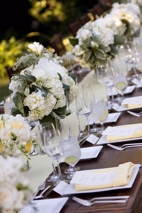 Fresh summer family-style wedding with all white florals, touches of yellow and custom printed menus