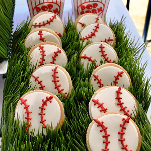 Cookies decorated with a baseball theme and cracker jacks in individual boxes