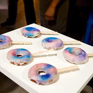 Mini galaxy donuts served on popsicle sticks
