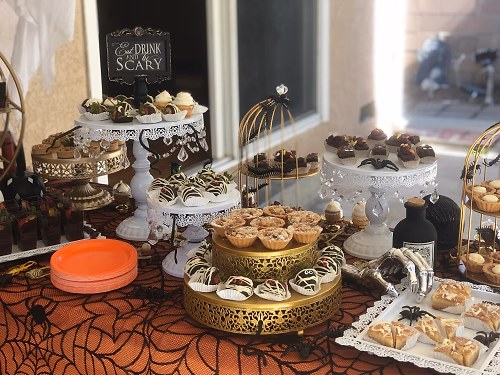 A Halloween dessert bar with mini autumn pies, mummy berries, dirt cups, ghost cupcakes, and gooey butter cake bars!