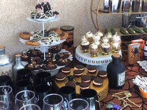 A Halloween dessert bar with mini autumn pies, mummy berries, dirt cups, ghost cupcakes, and gooey butter cake bars!