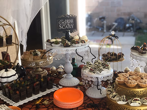 A Halloween dessert bar with mini autumn pies, mummy berries, dirt cups, ghost cupcakes, and gooey butter cake bars!