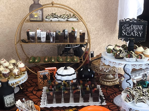 A Halloween dessert bar with mini autumn pies, mummy berries, dirt cups, ghost cupcakes, and gooey butter cake bars!