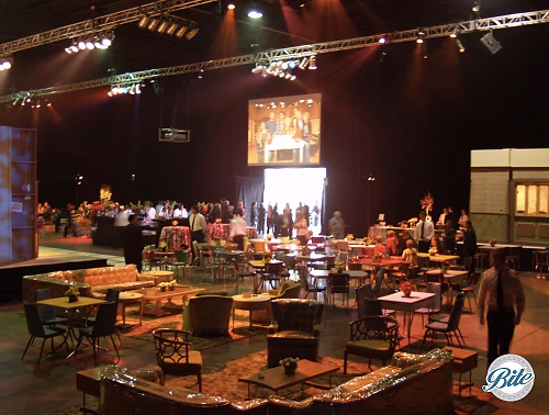 Video screens with tables, chairs, and couches layout
