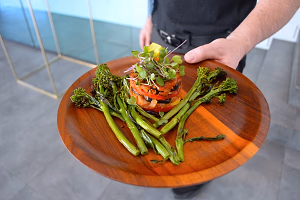 Pan - seared salmon on a wooden plate served with charred broccolini