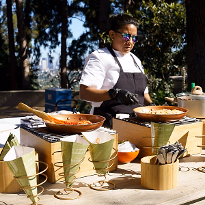 Chef in the action station for Tezza's pasta in a cone