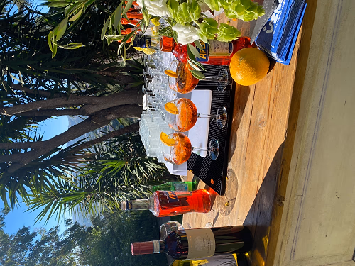 Outdoor cocktail station showing an Aperol and lemon drink