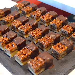 Gooey pecan bars dipped in dark chocolate